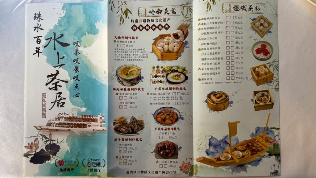 A colorful tri-fold menu showing various dim sum dishes at a Guangzhou boat restaurant.