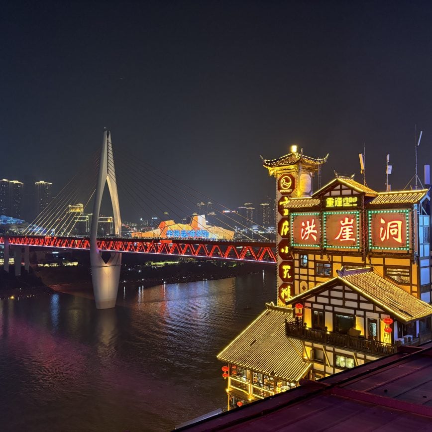 Panoramic night view of the Chongqing cyberpunk skyline with neon skyscrapers reflecting on the Yangtze River.