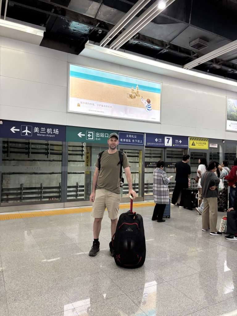 A man standing on the platform at Meilan Station in Haikou