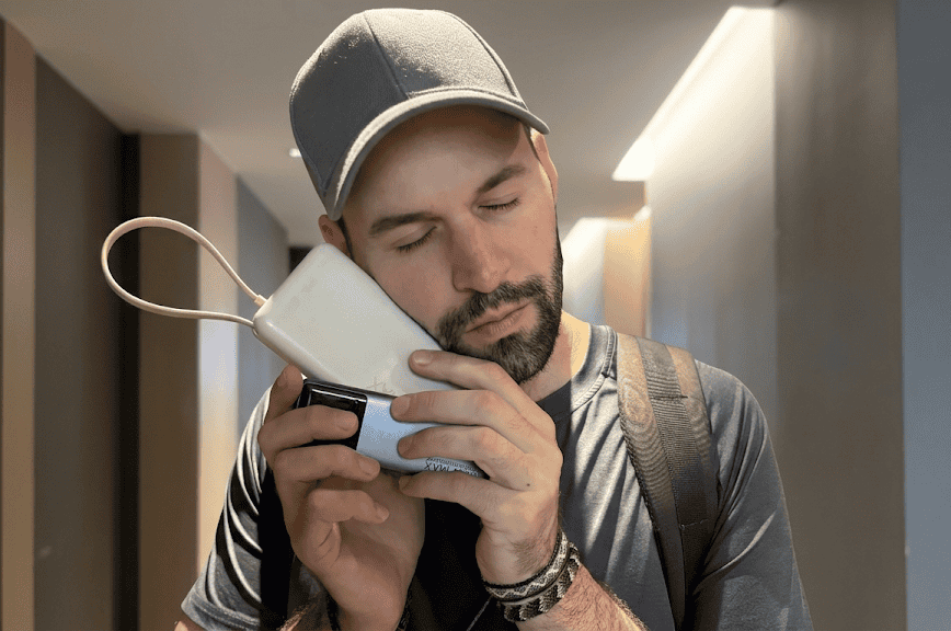 Traveler holding two portable power banks in an airport hallway to check for mandatory CCC certification marks required for China domestic flights.