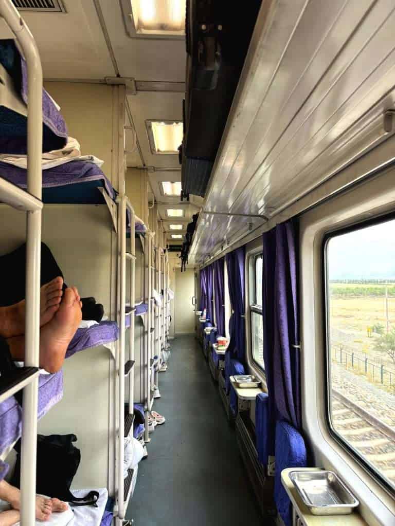 Hard sleeper carriage corridor, purple curtains and open bunks
