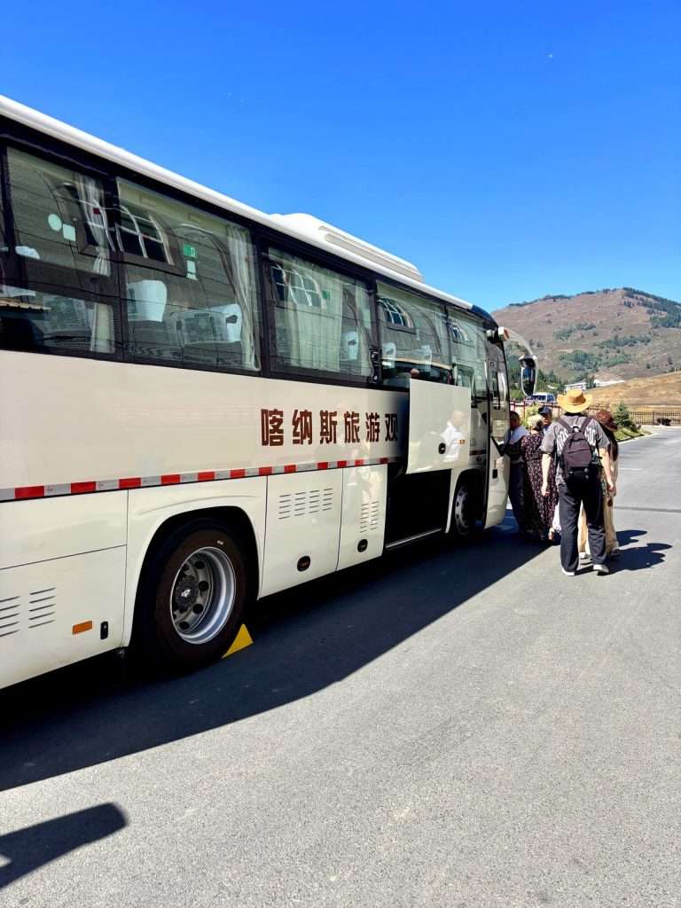 Passengers waiting at the bus stop connecting Hemu Village to Jiadengyu, Xinjiang