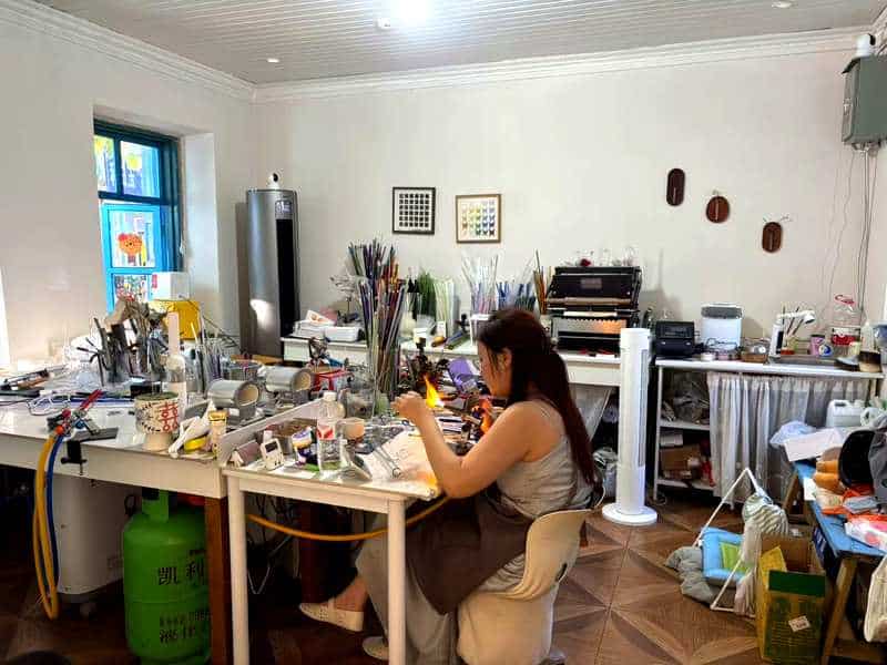 Handmade glass jewellery being crafted in a Liuxing Street Yining workshop
