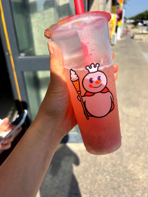 Holding a Mixue drink outside a shop in Bole