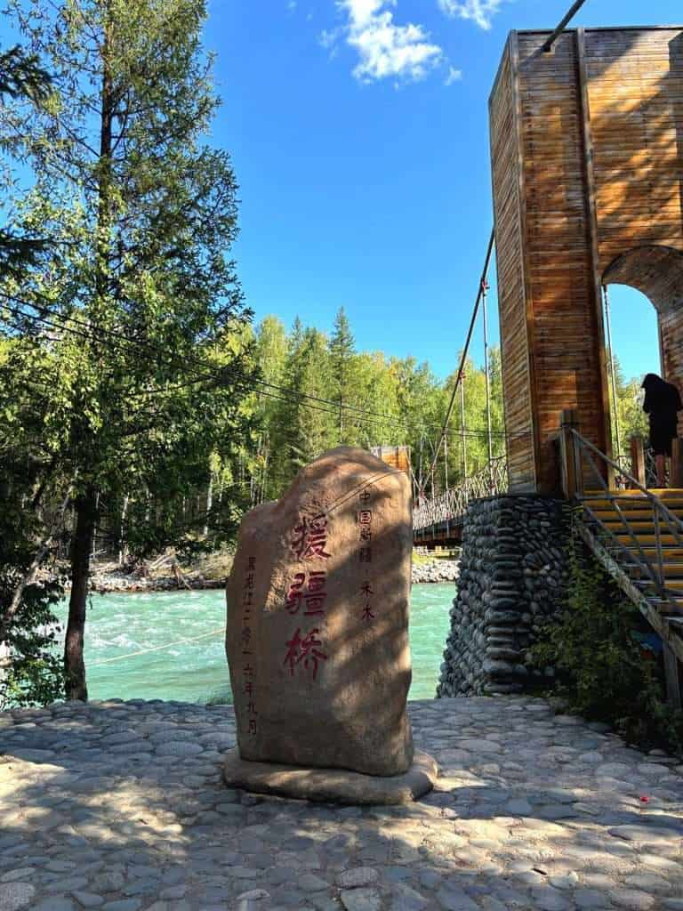 Xinjiang Aid Bridge in Hemu Village, wooden pedestrian bridge crossing the river