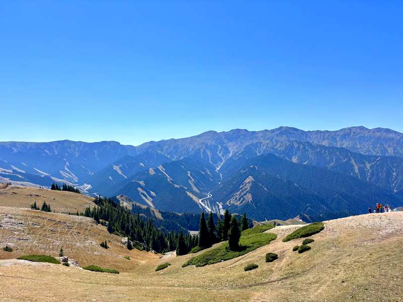 The boardwalk trail and distant view towards Guozigou Bridge from the top of Pine Head, Sayram Lake