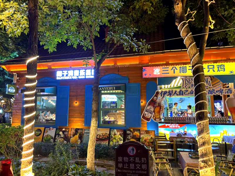 Nanyehui Coconut Chicken Hotpot restaurant signage in Yining at night