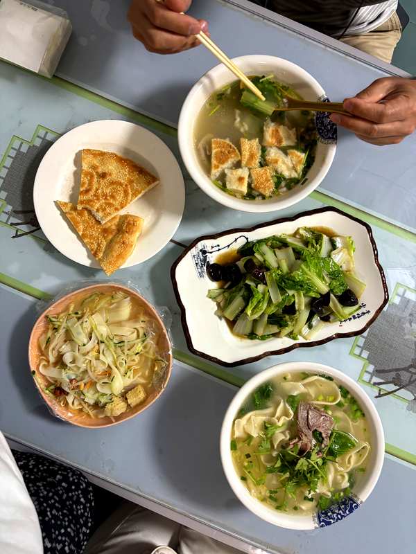 Dinner in Bole after our Sayram Lake day trip: lamb offal soup, stir-fried greens, beef noodles and more